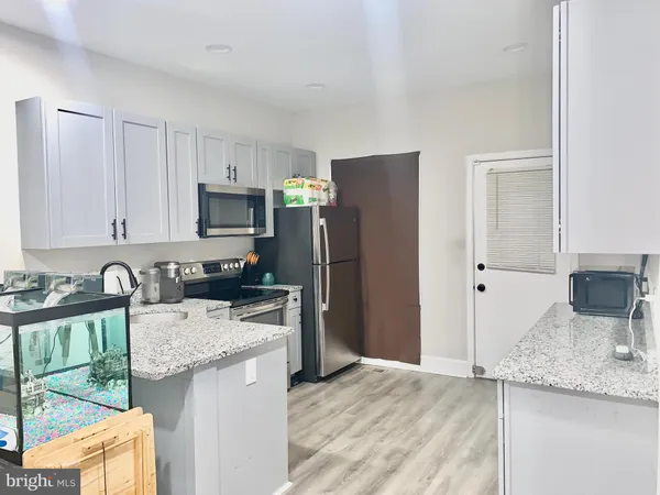 a kitchen with kitchen island granite countertop a sink stove and refrigerator