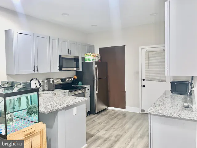 a kitchen with kitchen island granite countertop a sink stove and refrigerator