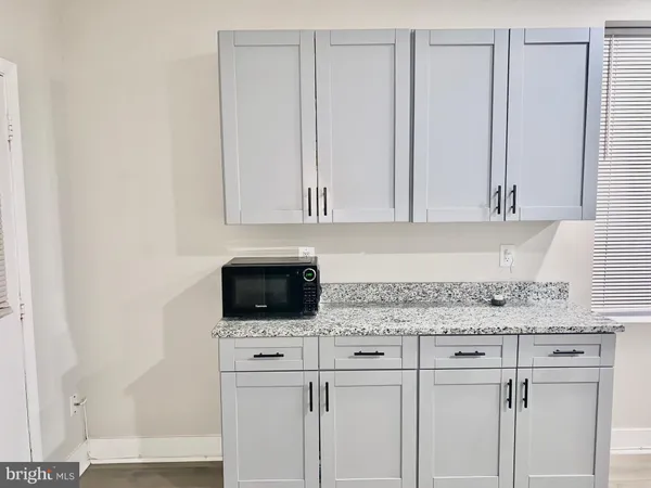 a kitchen with white cabinets and sink