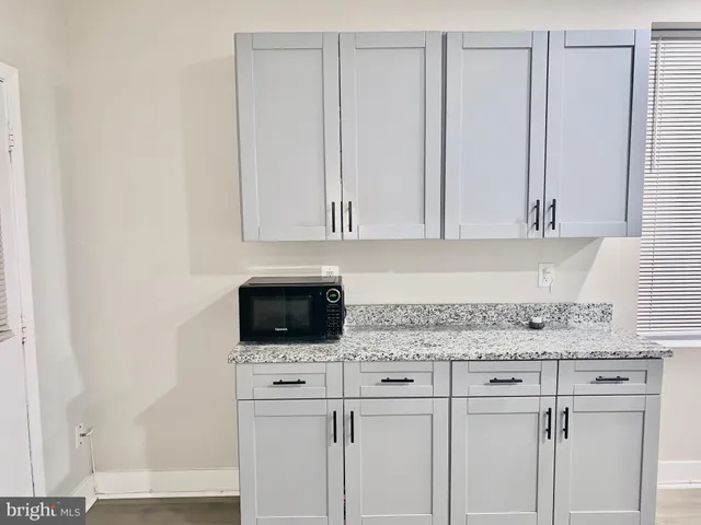 a kitchen with white cabinets and sink