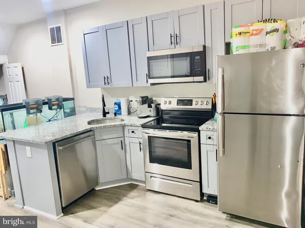 a kitchen with stainless steel appliances a stove microwave and refrigerator
