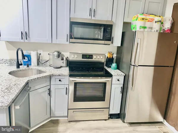 a kitchen with stainless steel appliances granite countertop a refrigerator stove and microwave