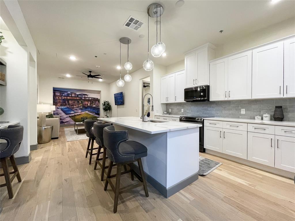 a kitchen with stainless steel appliances kitchen island granite countertop a sink a stove a dining table and chairs