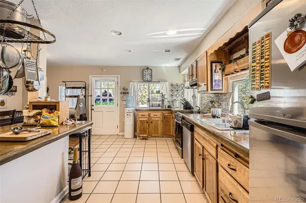 a kitchen with stainless steel appliances granite countertop a stove a sink and a refrigerator