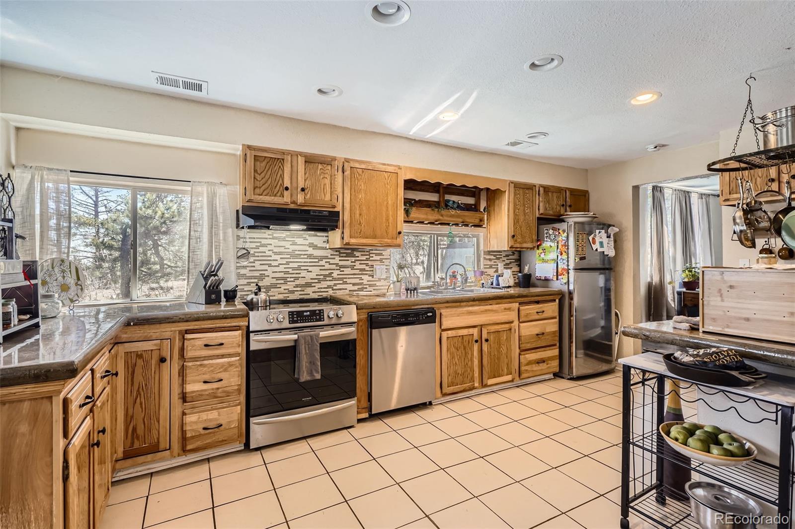 33 L Road Golden, CO 80403 - Photo 3 of 49 a kitchen with stainless steel appliances granite countertop a stove top oven a sink dishwasher a dining table and chairs with wooden floor