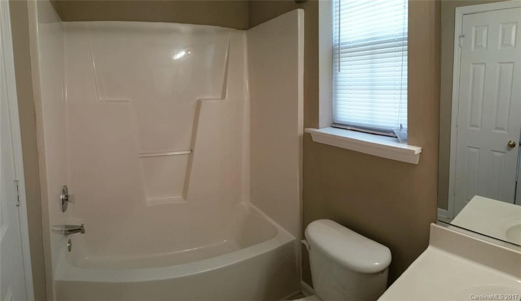 11203 Gold Pan Road Charlotte, NC 28215 - Photo 13 of 15 a white toilet sitting next to a bath tub