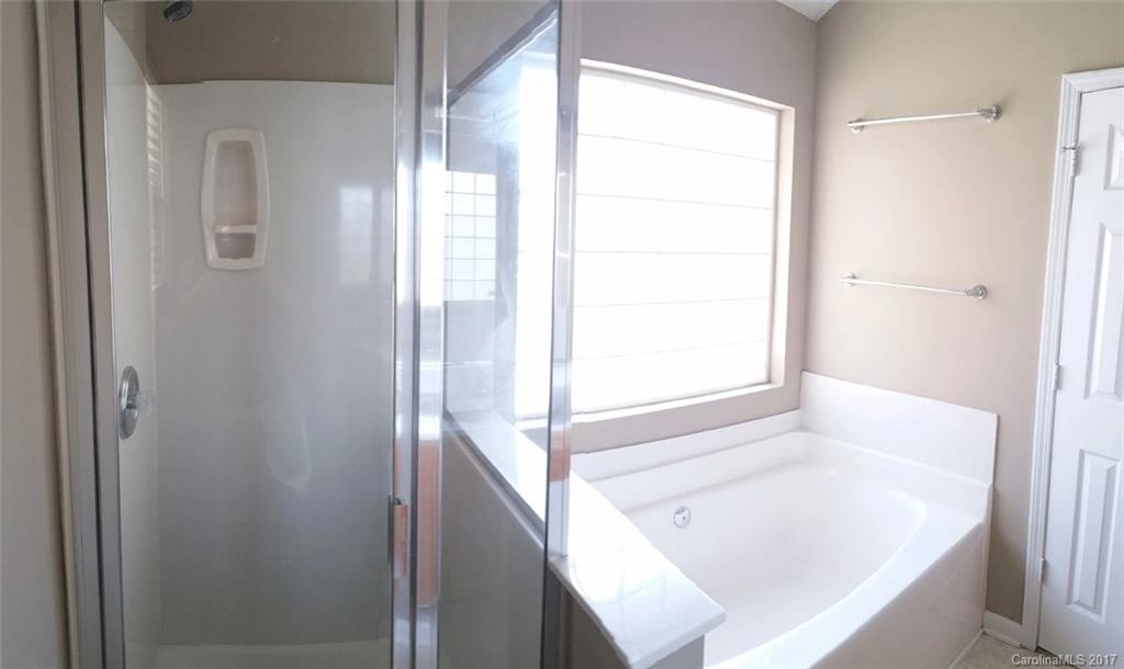 11203 Gold Pan Road Charlotte, NC 28215 - Photo 8 of 15 a bathroom with a bathtub and shower