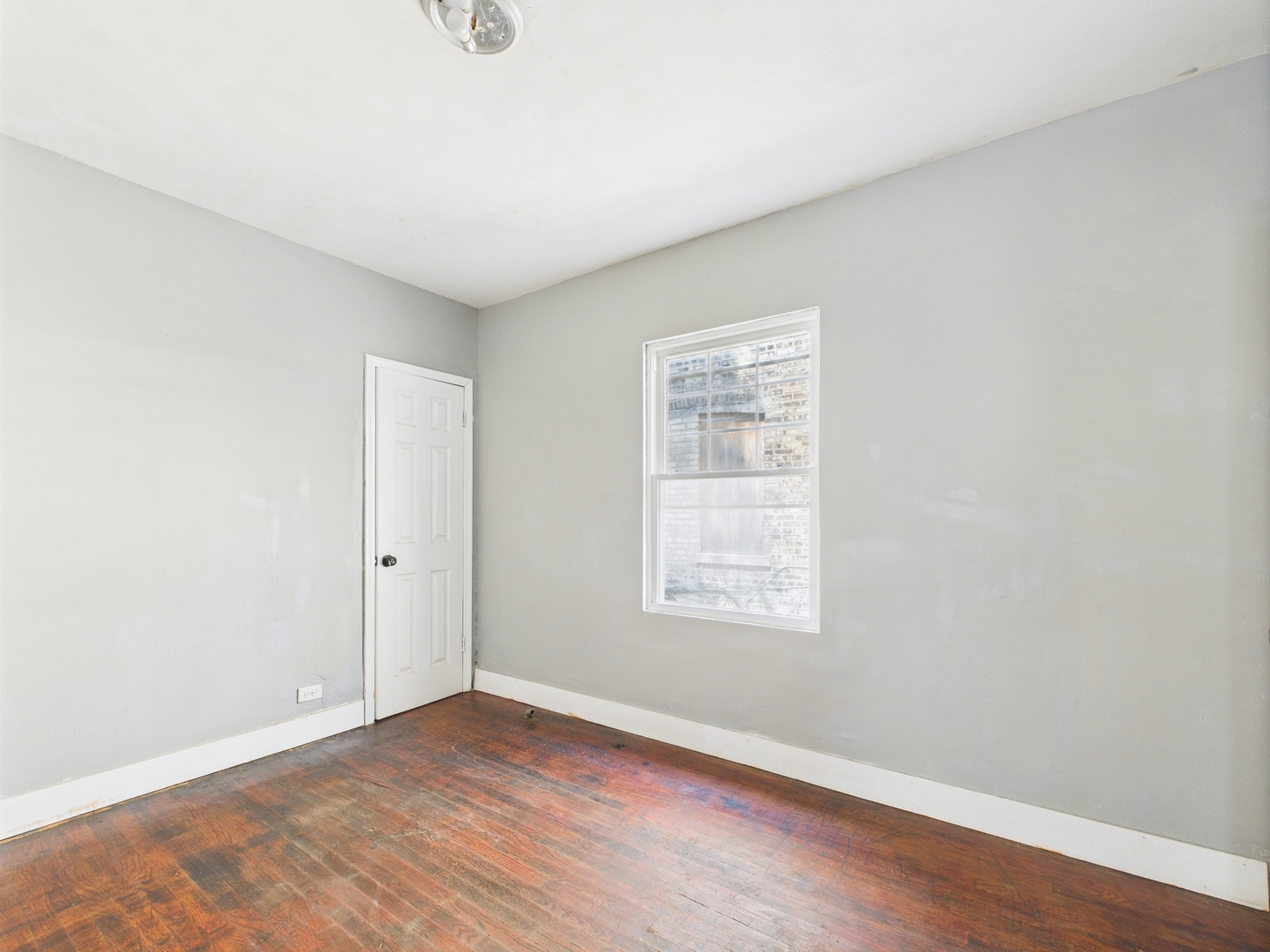 11922 South Perry Avenue Chicago, IL 60628 - Photo 11 of 23 an empty room with wooden floor and windows