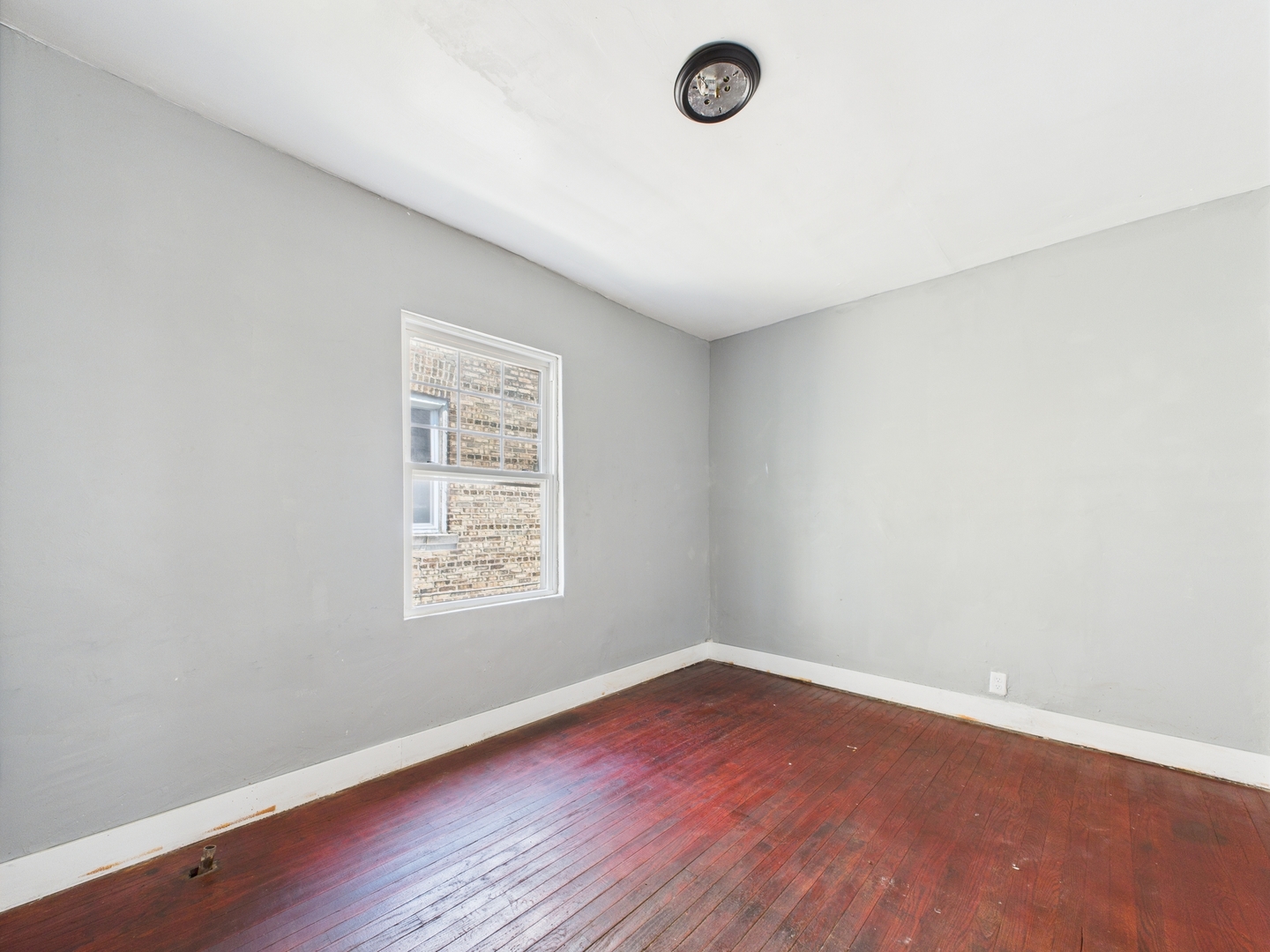 11922 South Perry Avenue Chicago, IL 60628 - Photo 18 of 23 an empty room with wooden floor and window