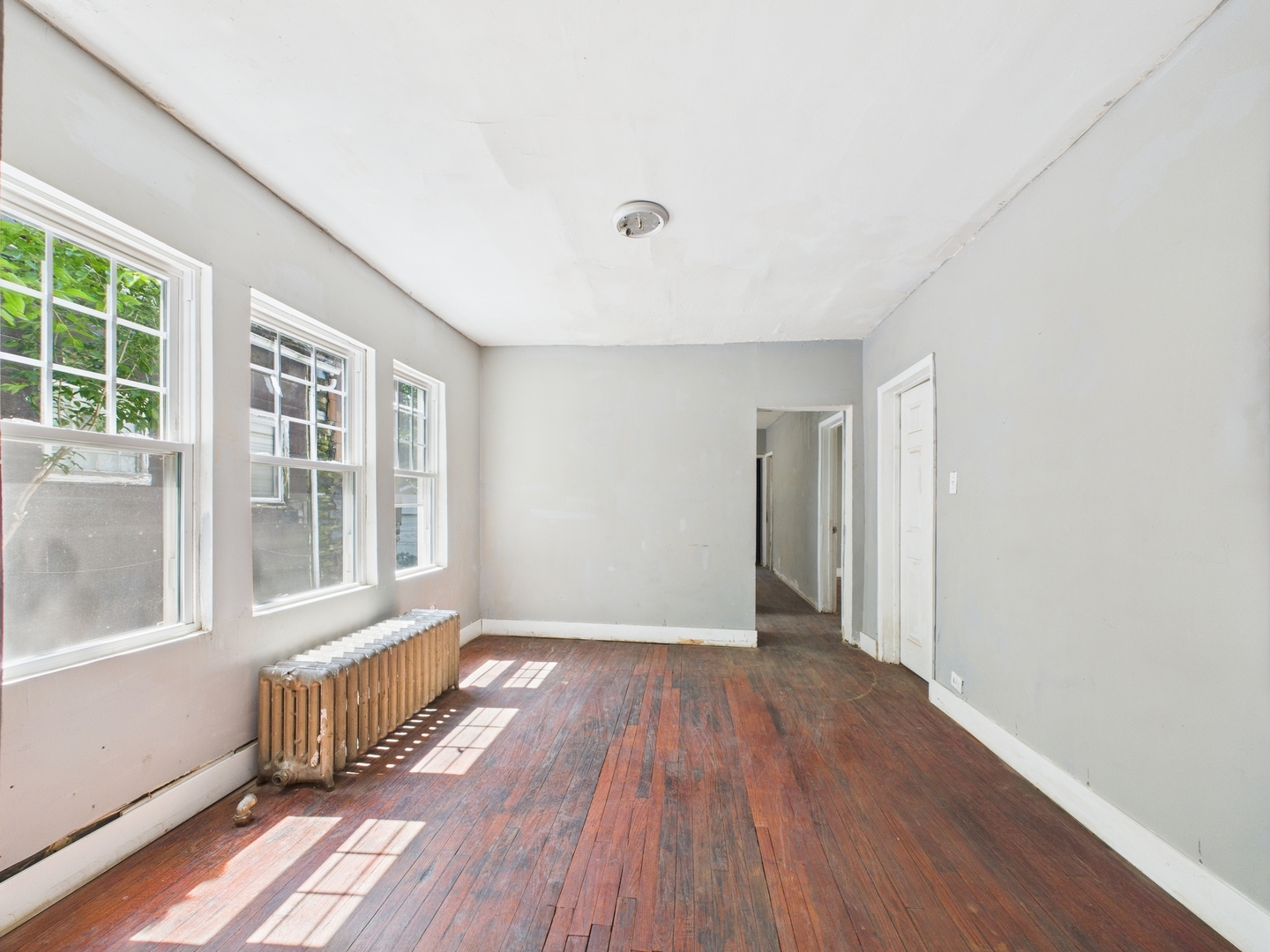 11922 South Perry Avenue Chicago, IL 60628 - Photo 6 of 23 an empty room with wooden floor and windows