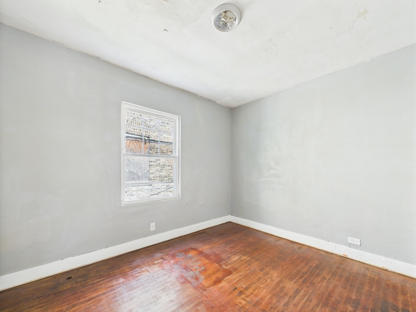 11922 South Perry Avenue Chicago, IL 60628 - Photo 8 of 23 an empty room with wooden floor and windows