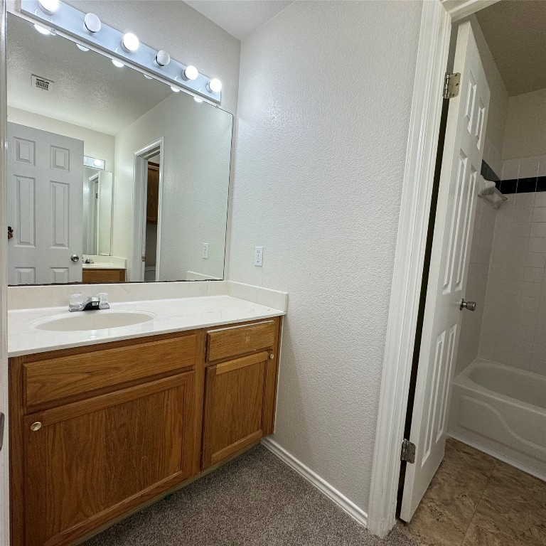 4735 Castleman Drive Austin, TX 78724 - Photo 14 of 16 a spacious bathroom with a double vanity sink a mirror and a bathtub