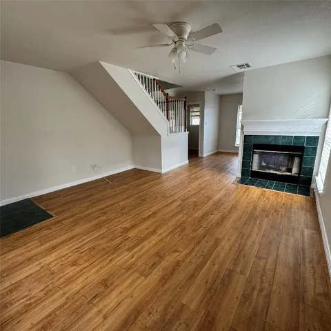 wooden floor fireplace and windows in an empty room