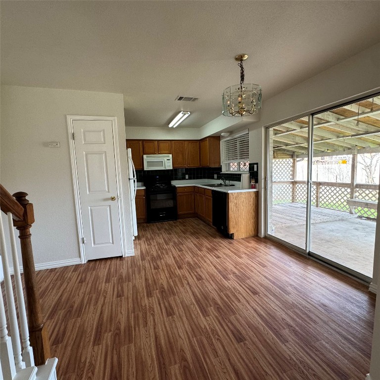 4735 Castleman Drive Austin, TX 78724 - Photo 4 of 16 a view of a kitchen with wooden floor electronic appliances and furniture