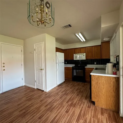 a kitchen with a refrigerator and a stove top oven
