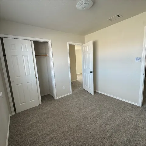 an empty room with closet and mirror