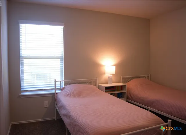 a bedroom with two beds and a window