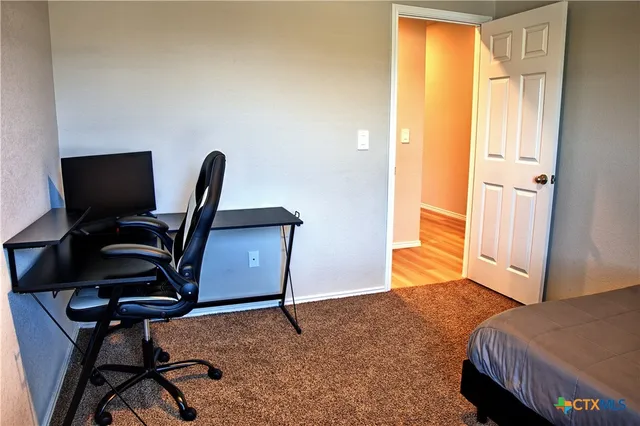 a view of a workspace with furniture and a window