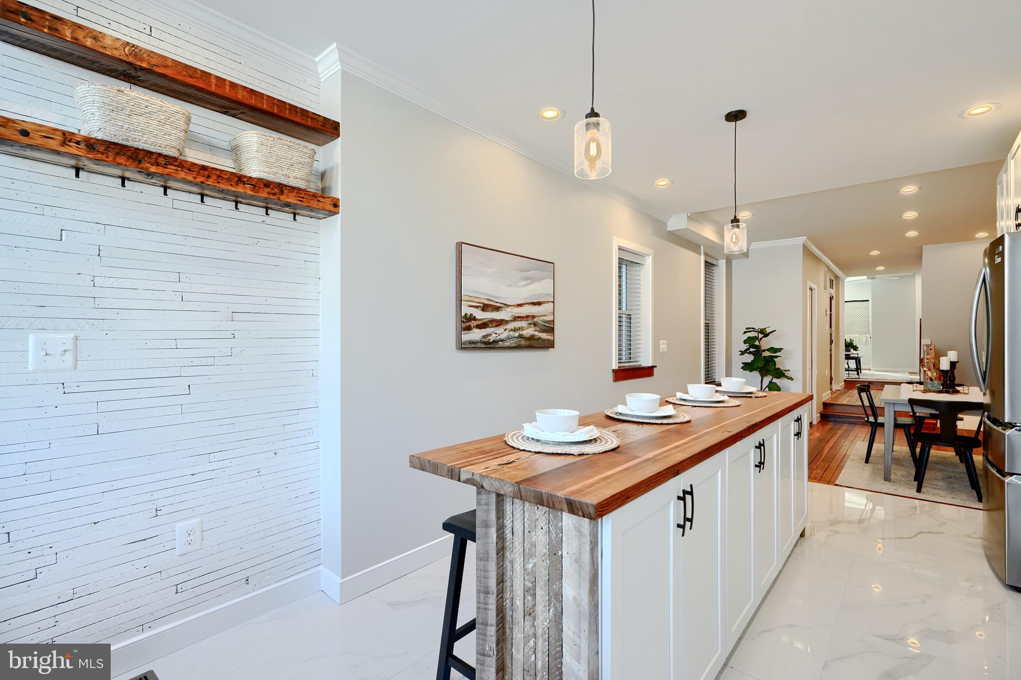 1435 Riverside Avenue Baltimore, MD 21230 - Photo 11 of 78 a kitchen with stainless steel appliances kitchen island a table chairs in it and wooden floors