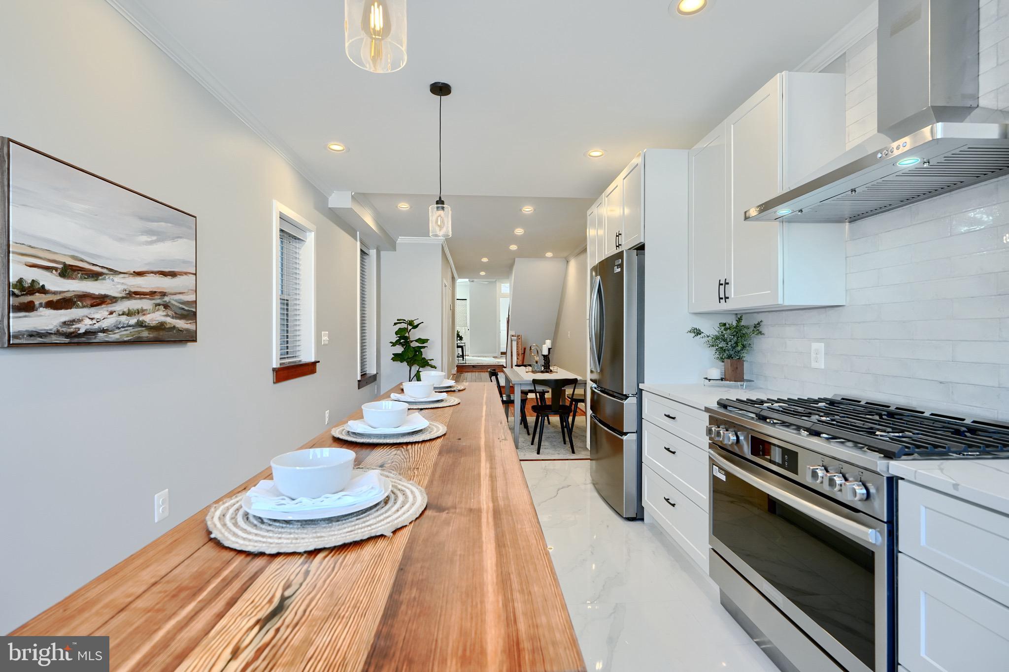 1435 Riverside Avenue Baltimore, MD 21230 - Photo 12 of 78 a kitchen with stainless steel appliances a table a stove and cabinets