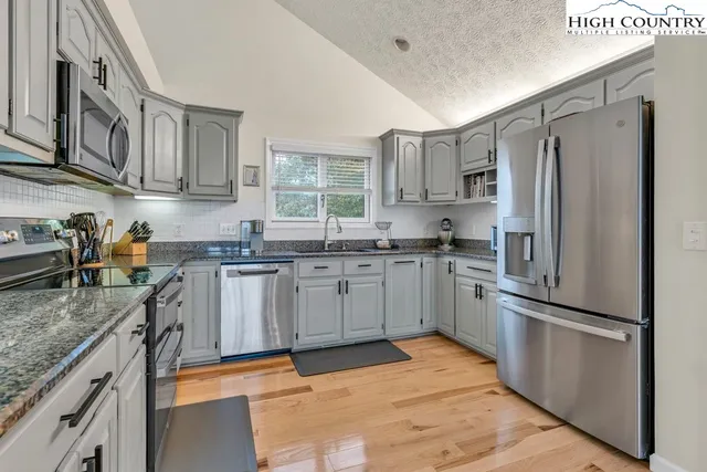 a spacious bedroom with a bed and a couch with window