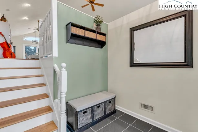 a kitchen with stainless steel appliances granite countertop a refrigerator a stove a sink dishwasher and white cabinets with wooden floor