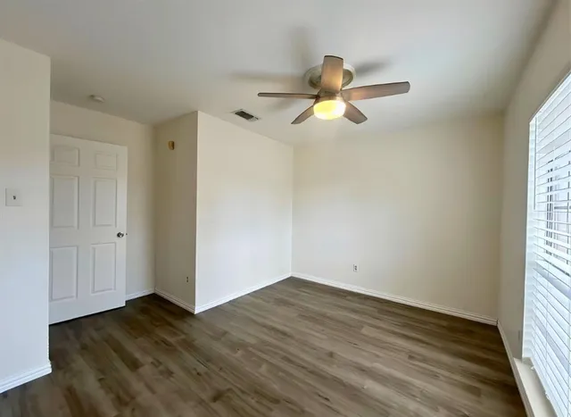 wooden floor in an empty room with a window