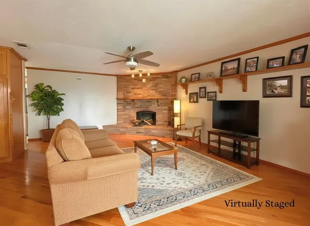 a view of empty room with wooden floor and fireplace