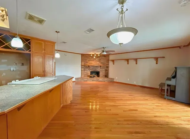 a large kitchen with a lot of counter space and wooden floor
