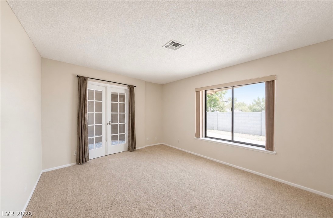 6491 West Viking Road Las Vegas, NV 89103 - Photo 2 of 5 Bright and adaptable room offering privacy with French doors and natural light through a generous window.