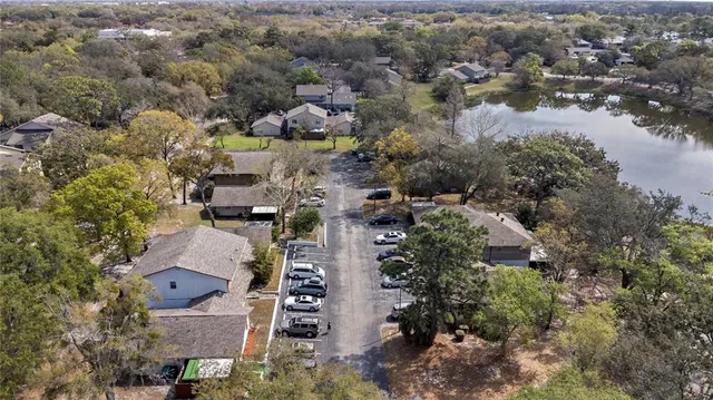 an aerial view of residential houses with outdoor space and trees