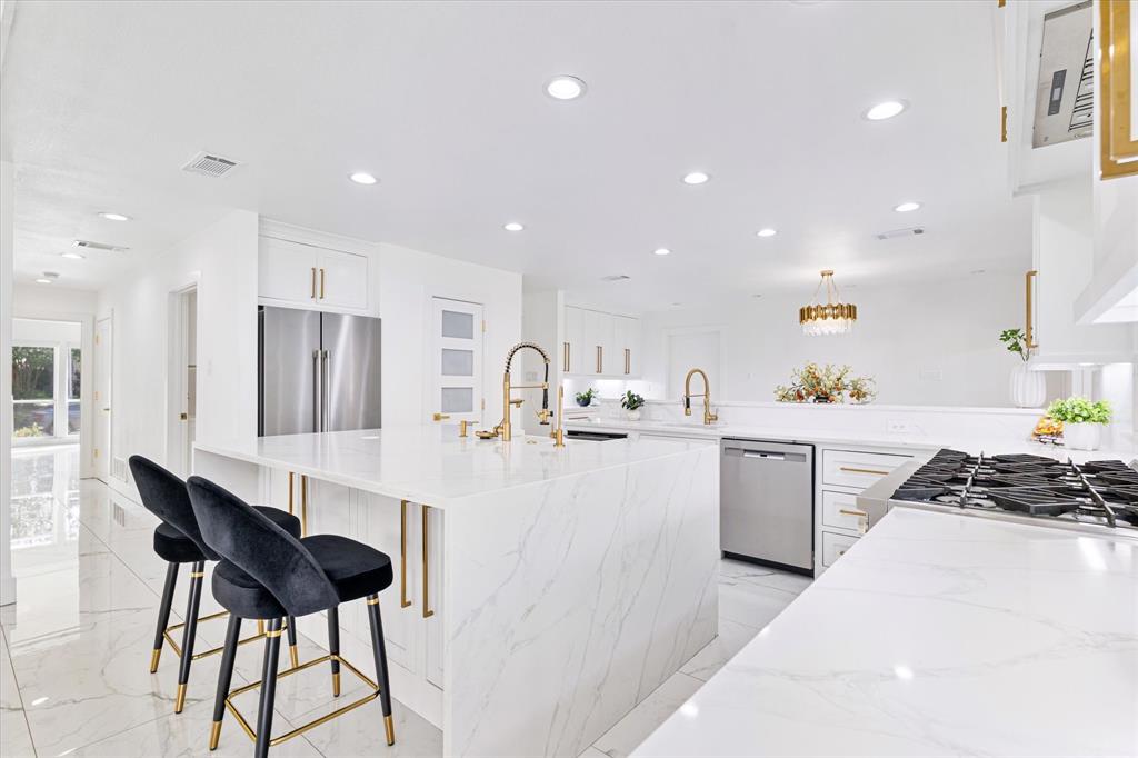 5407 Westgrove Drive Dallas, TX 75248 - Photo 16 of 40 a kitchen with stainless steel appliances kitchen island granite countertop a sink and chairs