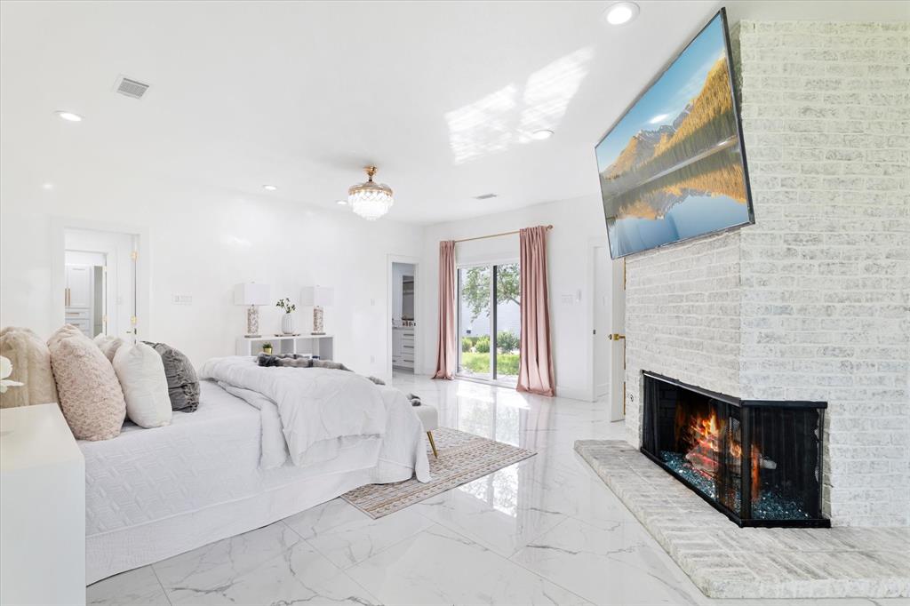 5407 Westgrove Drive Dallas, TX 75248 - Photo 20 of 40 a spacious bedroom with a bed and a fireplace