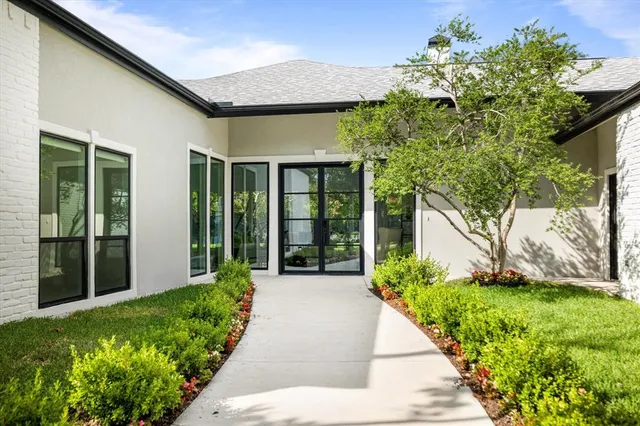 a front view of a house with a yard and potted plants