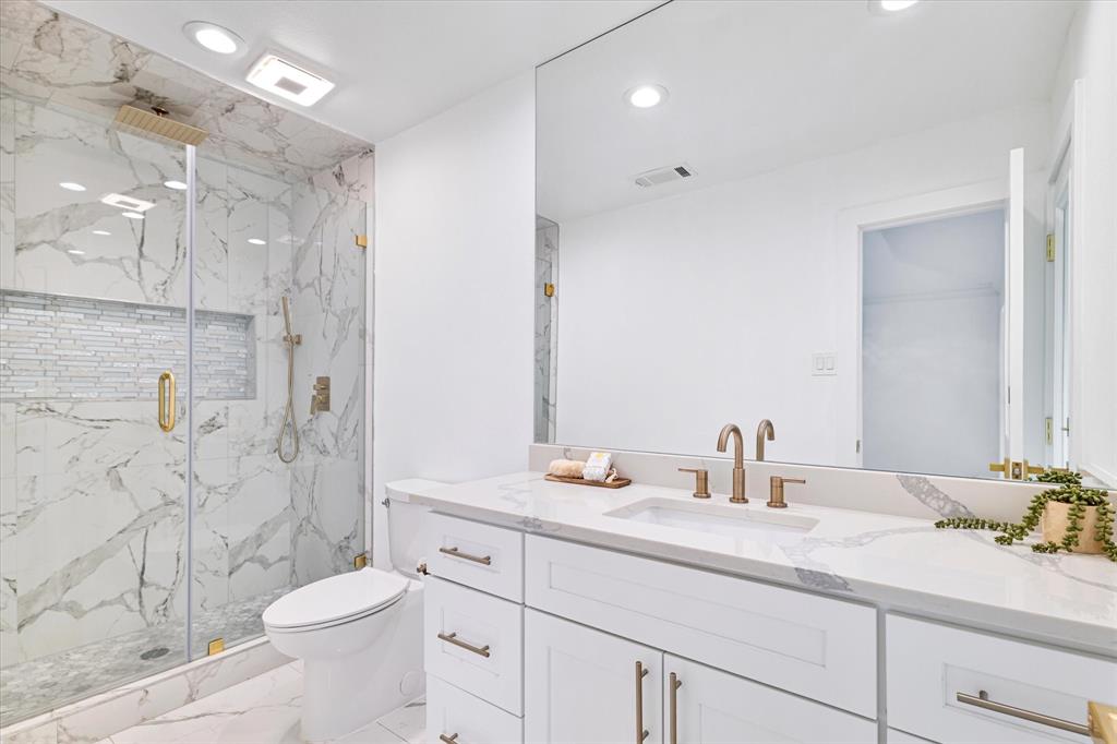 5407 Westgrove Drive Dallas, TX 75248 - Photo 35 of 40 a bathroom with a granite countertop sink a toilet a shower and a mirror