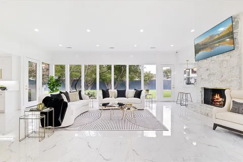 a living room with furniture large window and a fireplace