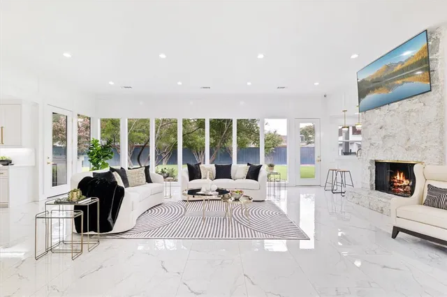 a living room with furniture large window and a fireplace