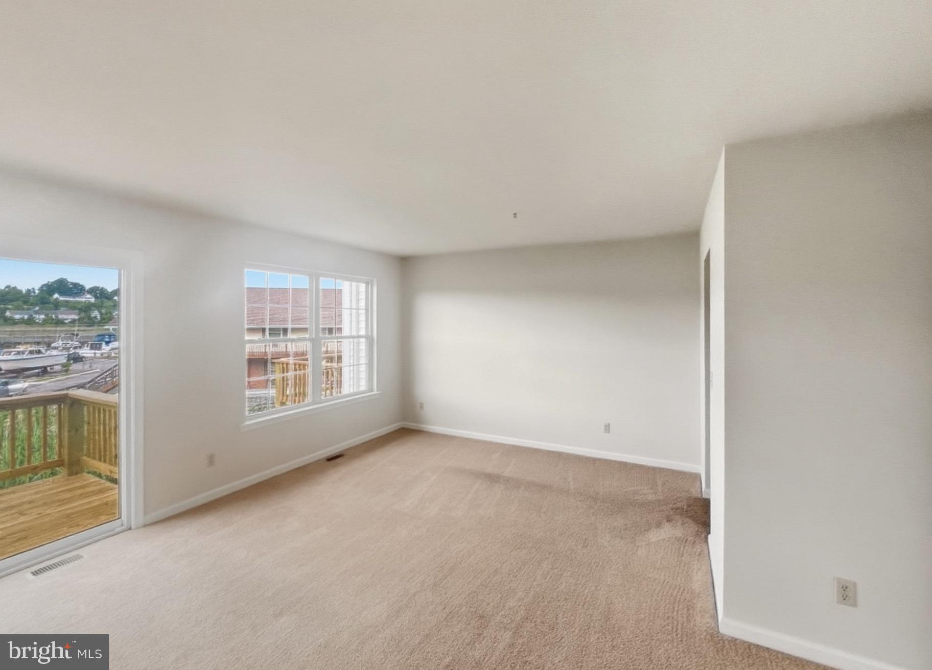 3607 Harbor Road Chesapeake Beach, MD 20732 - Photo 2 of 27 an empty room with a fireplace and windows