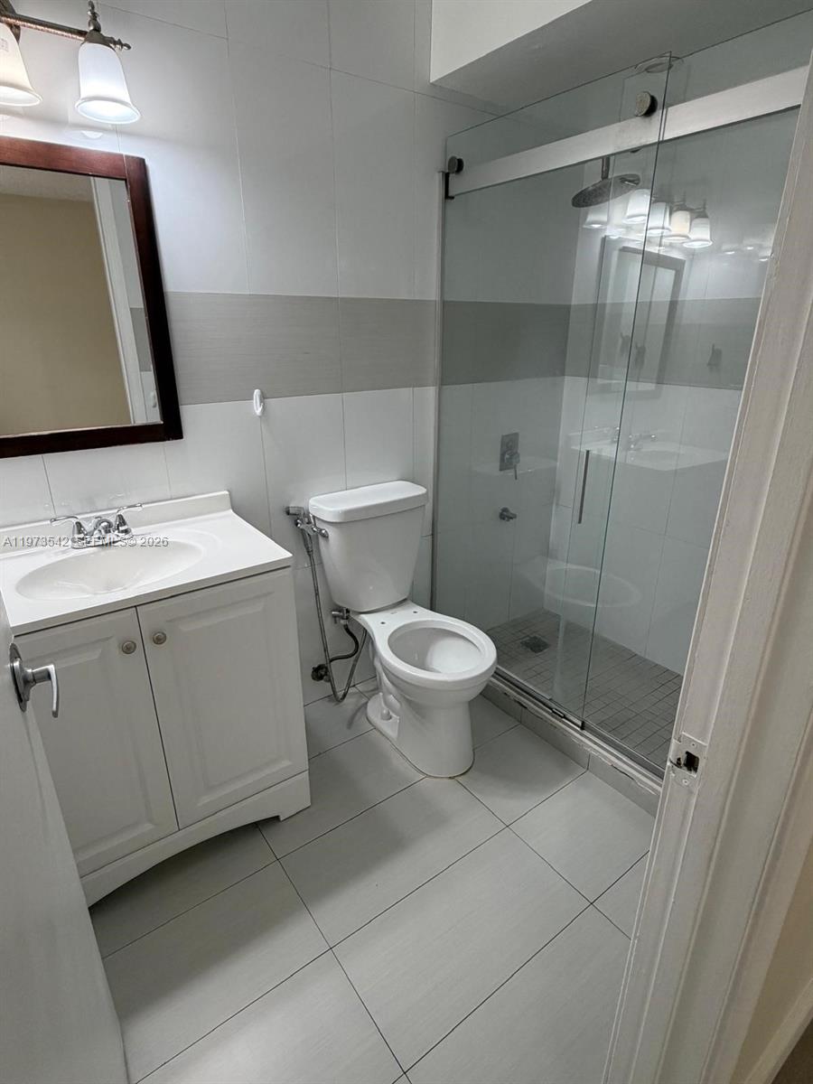 5252 Southwest 139th Place, Unit 5252 Miami, FL 33175 - Photo 18 of 18 a bathroom with a sink a toilet a mirror and shower