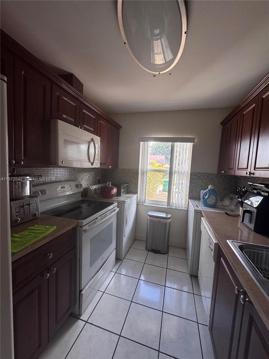 5252 Southwest 139th Place, Unit 5252 Miami, FL 33175 - Photo 4 of 15 a kitchen with a sink a stove and cabinets