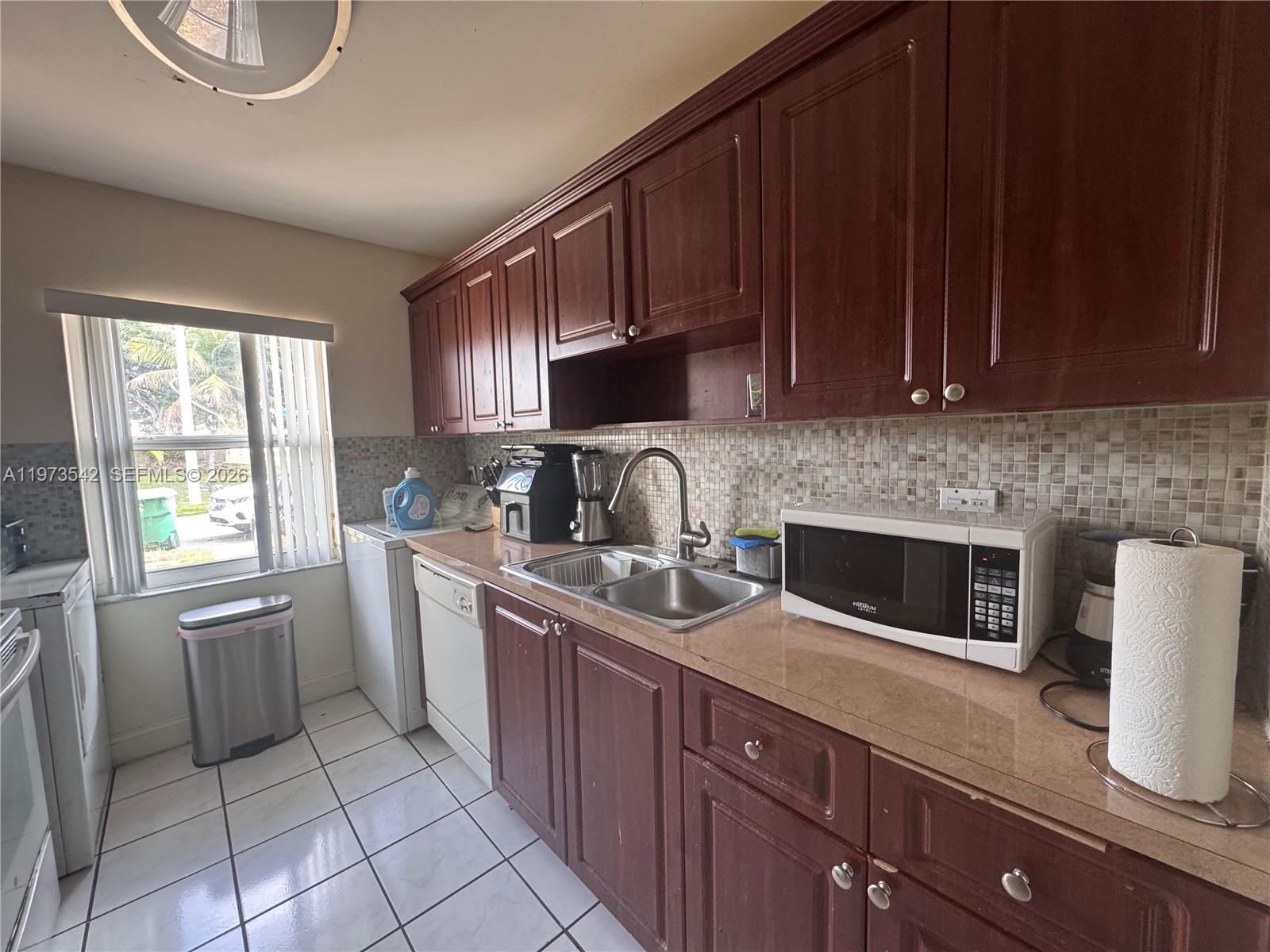 5252 Southwest 139th Place, Unit 5252 Miami, FL 33175 - Photo 5 of 15 a kitchen with stainless steel appliances granite countertop a sink stove refrigerator and cabinets