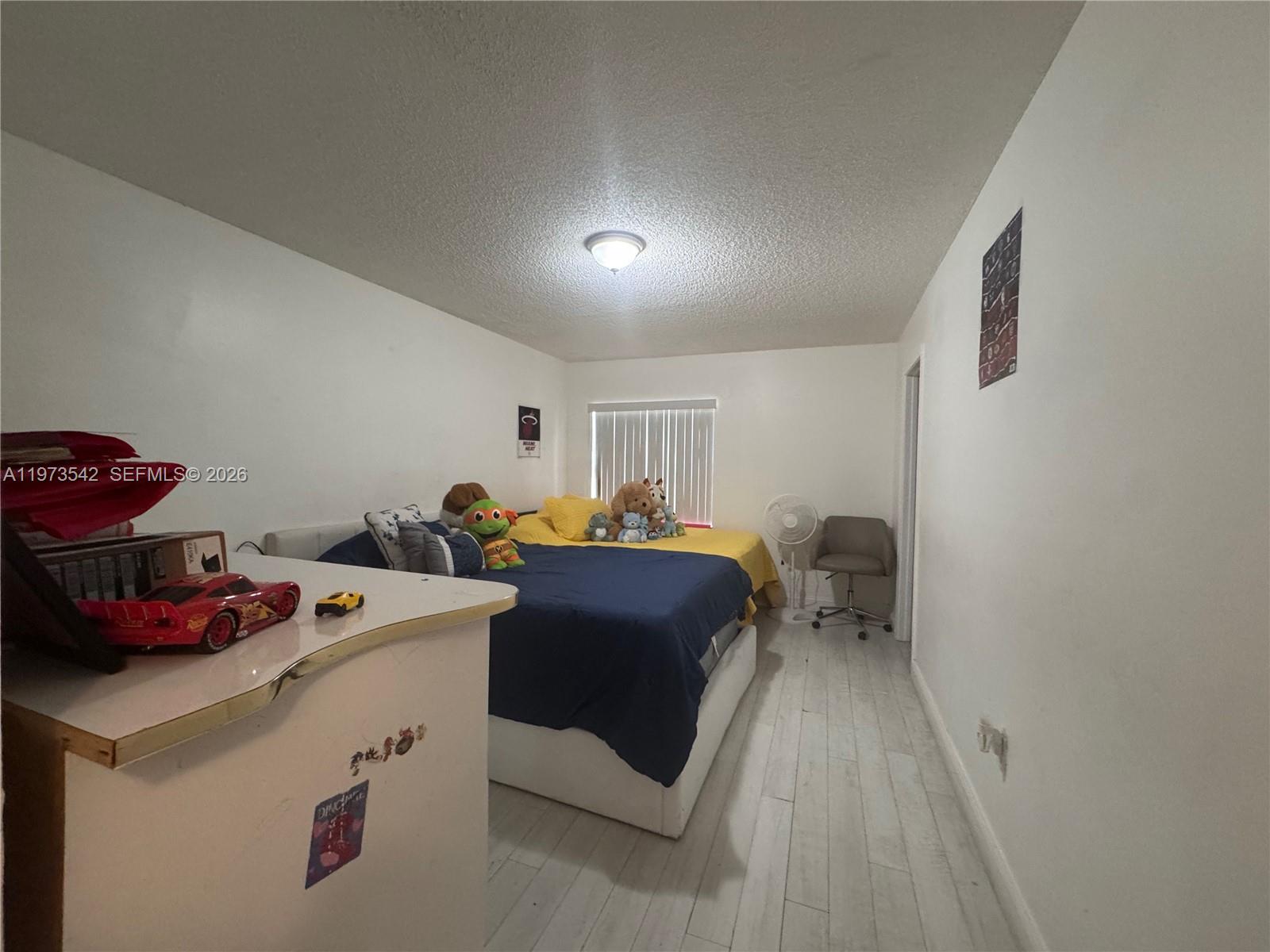 5252 Southwest 139th Place, Unit 5252 Miami, FL 33175 - Photo 8 of 18 a bed room with a bed and a chair