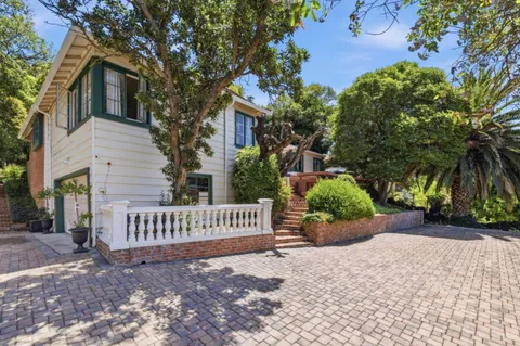 a view of a house with a yard and a bench