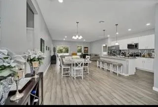 a kitchen with stainless steel appliances kitchen island granite countertop a table chairs and a stove