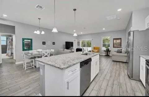 a kitchen with a stove and a wooden floor