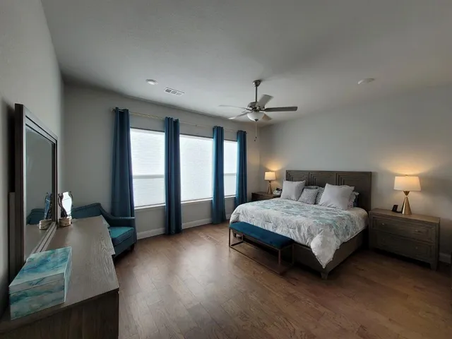 a spacious bedroom with a large bed and a chandelier