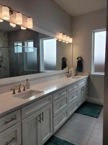 a bathroom with double sink and a mirror