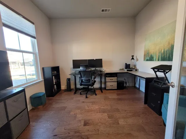 a view of a workspace with furniture and a window