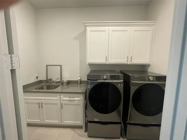 a utility room with sink dryer and washer