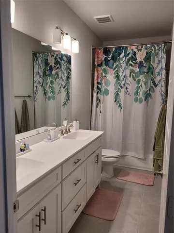 a bathroom with a granite countertop sink a toilet and a mirror